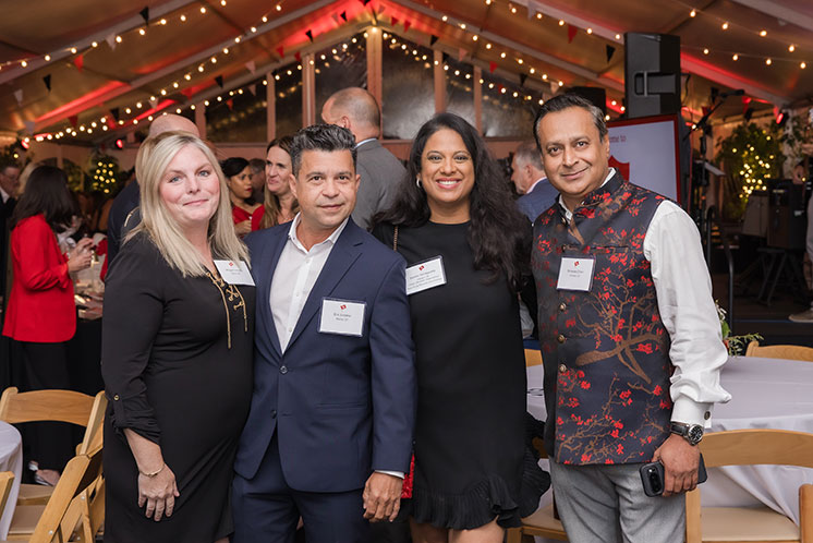 Four people standing together at an event. Links to Donor-Advised Funds Four people standing together at an event. Links to Donor-Advised Funds