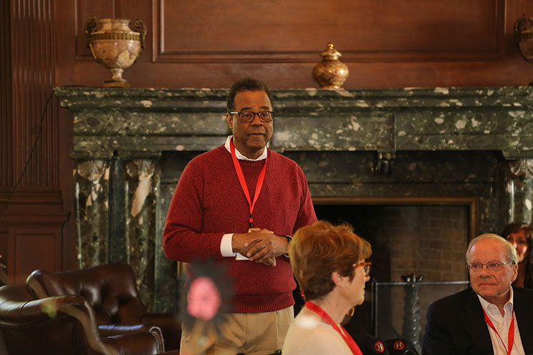 A man patiently waits for any questions from the people sitting at an event. A man patiently waits for any questions from the people sitting at an event.